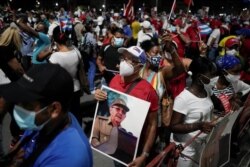 A man holds an image of Cuba's former President and First Secretary of the Communist Party Raul Castro during a rally amid concerns about the spread of the coronavirus disease (COVID-19) in Havana, Cuba, July 17, 2021. REUTERS/Alexandre Meneghini
