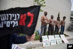 FILE - African migrants wear chains to represent slavery during a demonstration in Tel Aviv, Israel, April 3, 2018.