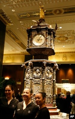 Employees of the spa at New York's renowned Waldorf Astoria pose for a photo in front of the famous clock on the hotel's first floor, Feb. 28, 2017. The bastion of gilded splendor closed March 1 for massive renovations.