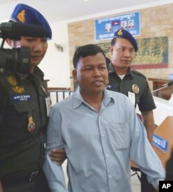 រូប​ឯកសារ៖ លោក​ ជាម​ ច័ន្ទនី​ តំណាង​រាស្ត្រ​គណបក្ស​ប្រឆាំង​ត្រូវ​មន្ត្រី​កង​រាជ​អាវុធ​ហត្ថ​នាំខ្លួន​ក្រោយ​ពី​ត្រូវ​បាន​តុលាការយោធា​នៅ​ភ្នំពេញ​ជំនុំ​ជម្រះ​កាល​ពី​ថ្ងៃ​ទី​៩ ខែ​សីហា ឆ្នាំ​២០០៥។ លោក​ត្រូវ​តុលាការ​កាត់​ទោស​ឲ្យ​ជាប់​ពន្ធនាគារ​ចំនួន​៧​ឆ្នាំ​ពី​បទការ​កេណ្ឌ​កងទ័ព​ស្រមោល​ ដើម្បី​ផ្តួល​រំលំ​រដ្ឋាភិបាល។ (AP Photo/Andy Eames)