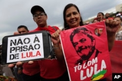 Demonstrators carry signs written in Portuguese that read "No Prison for Lula," left, and "I'm with Lula," during a protest in support of Brazil's former President Luiz Inacio Lula da Silva, in Brasilia, Brazil, April 4, 2018.