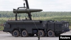 FILE - Russian servicemen equip an Iskander tactical missile system at the Army-2015 international military-technical forum in Kubinka, outside Moscow, Russia, June 17, 2015. 