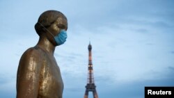 Sebuah patung di Trocadero dekat menara Eiffel memakai masker selama wabah COVID-19 di Paris, Prancis, 2 Mei 2020. (Foto: Reuters/Benoit Tessier)