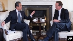 资料照片: 2015年6月9日时任英国首相卡梅伦(右)在伦敦唐宁街10号会见中国外交部长王毅