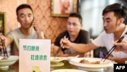 中国河北邯郸市一家餐馆桌子上立有“节约粮食杜绝浪费”的牌子。（2020年8月13日）法新社