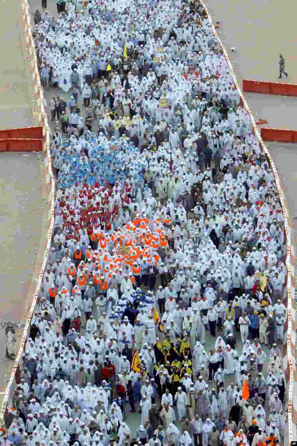Muslim pilgrims walk to cast stones at pillars, symbolizing the stoning of Satan, in a ritual called "Jamarat," a rite of the annual Hajj, in Mina near the holy city of Mecca, Saudi Arabia, Oct. 16, 2013.