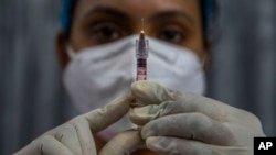 FILE - In this Friday, Jan. 8, 2021, file photo, a health worker checks a syringe before performing a trial run of COVID-19 vaccine delivery system, as India's prepare to kick off the coronavirus vaccination drive on Jan. 16, in Gauhati, India. (AP Photo/Anupam Nath, File)