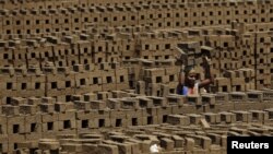 A laborer carries bricks at a kiln in Karjat, India, March 10, 2016. Thousands of brick kiln workers in India's western Maharashtra state are learning from activists that they have the right to a minimum wage, basic amenities and fair treatment - but remain in debt bondage to owners who deny them these rights with impunity.