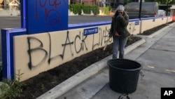 Joan Nicolai, the gardener at Gate City Bank in downtown Fargo, N.D., pauses to catch her breath during an early morning cleanup, May 31, 2020. 