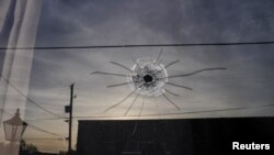 Lobang bekas tembakan peluru terlihat di kaca dari pintu masuk studio tari Mahogany Masterpiece di Dadeville, Alabama, pada 16 April 2023, menyusul insiden penembakan di tempat tersebut sehari sebelumnya. (Foto: Reuters/Cheney Orr)