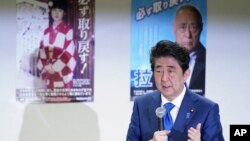 FILE - Japanese Prime Minister Shinzo Abe delivers remarks to families of Japanese citizens abducted by North Korea, in front of abduction awareness posters during an event in Tokyo, Japan, April 22, 2018.