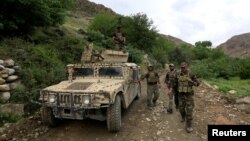 FILE - Afghan Special Forces patrol at the site where a MOAB, or ''mother of all bombs," was dropped on the Achin district of the eastern province of Nangarhar, Afghanistan, April 23, 2017. 
