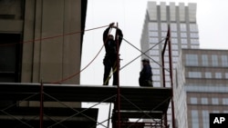FILE- Construction workers work in midtown Manhattan in New York, Feb. 20, 2018.