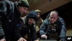 فرمانده اوکراینی از واحد موسوم به «کورت» در کنار همرزمانش در خط مقدم در منطقه دونتسک. ۱۳ فوریه ۲۰۲۳. آسوشیتدپرس.