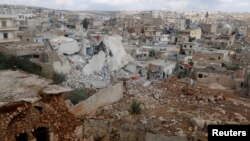 FILE - People inspect a site hit by what residents said were airstrikes carried out by the Russian air force in the town of Darat Izza in the province of Aleppo, Oct. 7, 2015. 