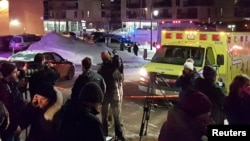 Ambulans diparkir di lokasi penembakan di Pusat Kebudayaan Islam Quebec di Quebec City, Kanada (29/1). (Reuters/Mathieu Belanger)