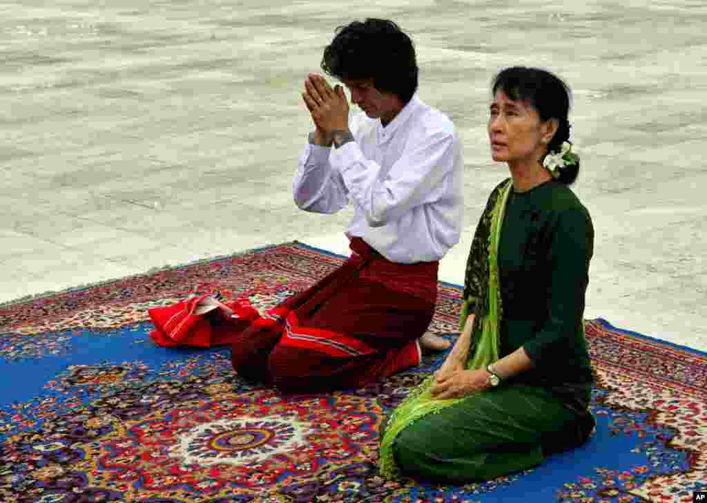 Aung San Suu Kyi and her youngest son Kim Aris pay respect to her father, the late Geneneral Aung San, at the Martyr's Mausoleum in Rangoon, Burma, July 12, 2011. 