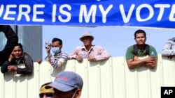 កម្មករ​ខ្មែរ​មើល​មក​លើ​បាតុកម្ម​របស់​គណបក្ស​សង្គ្រោះ​ជាតិ​នៅ​ទី​លាន​ប្រជាធិបតេយ្យ​​កាល​ពី​ថ្ងៃ​​ទី​៧​ខែ​កញ្ញា​ឆ្នាំ​២០១៤ ដោយ​​មាន​ផ្លាក​មួយ​ចង​ពី​​ថា​«តើ​សំឡេង​ឆ្នោត​ខ្ញុំ​នៅ​ឯ​ណា?»។