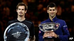Novak Djokovic, kanan, dari Serbia memegang pialanya setelah mengalahkan Andy Murray, kiri, dari Inggris pada babak final tunggal putra di kejuaraan tenis Australian Terbuka di Melbourne, Australia, 31 Januari 2016.