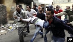 埃及人在开罗抬着在警民冲突中受伤者