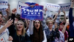 FILE - Supporters of then Republican presidential candidate Donald Trump cheer during a campaign rally, Nov. 8, 2016, in Grand Rapids, Michigan. With no clear indications where voter support for President Trump will go between now and the November 2018 midterm election, the vote may become a tough fight for survival for many Republican lawmakers.