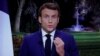 Presiden Prancis Emmanuel Macron terlihat di layar saat menyampaikan pidato Tahun Baru kepada bangsanya di Istana Elysee di Paris, Prancis, 31 Desember 2021. (Foto: REUTERS/Christian Hartmann)