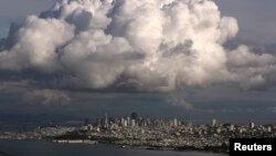 A large cloud gathers over the skyline of San Francisco, California, Dec. 12, 2014. While the Pacific Northwest is expected to have a mild winter, California's forecast is unsure.