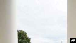 도널드 트럼프 미국 대통령이 10일 백악관 발코니에서 연설하기 위해 마스크를 벗으며 지지자들에게 손짓하고 있다.