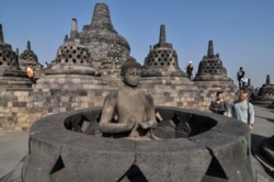 Para turis melihat-lihat patung Buddha di Candi Borobudur di Magelang, Jawa Tengah, 12 Agustus 2019. (Foto: AP/Slamet Riyadi)