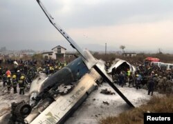 Wreckage of an airplane is pictured as rescue workers operate at Kathmandu airport, Nepal, March 12, 2018.