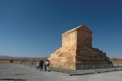 FILE - Tourists pose for a picture in front of the Tomb of Cyrus II in the southern Iranian city of Shiraz on Sept. 26, 2018.