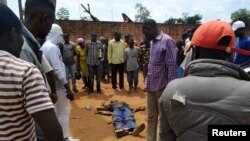 FILE - Civilians gather to look at the dead body of an unidentified man killed during fighting between the army and militia fighters in Beni, eastern Democratic Republic of the Congo, June 22, 2017.