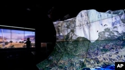 Falco Kuester, a researcher at ALERTCalifornia, a program run by the University of California San Diego, looks at imagery of firefighters at a fire from one of the program's cameras, alongside a digital rendering of Yosemite Valley, Sept. 18, 2023, in San Diego.