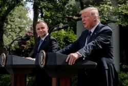 FILE - Poland's President Andrzej Duda listens to U.S. President Donald Trump during a joint news conference in the Rose Garden at the White House in Washington, June 24, 2020.