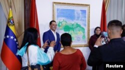 People take photos during an event to unveil a map of Venezuela showing Guyana's Essequibo region as part of the country, in Caracas, Venezuela, on Dec. 8, 2023.