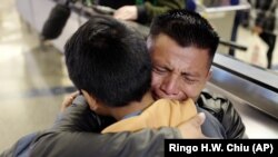 In this Wednesday, Jan. 22, 2020, file photo, David Xol-Cholom, of Guatemala, hugs his son Byron at Los Angeles International Airport as they reunite after being separated during the Trump administration's wide-scale separation of immigrant families.