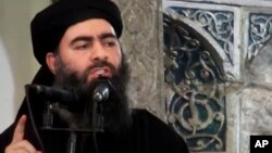 FILE - This image made from video posted on a militant website July 5, 2014, purports to show the leader of the Islamic State group, Abu Bakr al-Baghdadi, delivering a sermon at a mosque in Iraq.