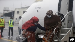 FILE - Passengers wearing face masks to protect against coronavirus disembark from a plane arriving from Abuja at the Murtala Mohammed Airport in Lagos, Nigeria, on July 9, 2020. 