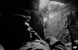 An East Pakistan (present-day Bangladesh) soldier uses a field telephone in a bunker as another soldier peers inside, near Jessore, East Pakistan, Dec. 3, 1971. The Pakistani soldiers had been shelled by Indian artillery.