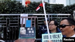 香港抗议者在圣诞节在中联办前摆放一张空椅子和刘晓波遗孀刘霞的照片，呼吁中国当局解除对刘霞的软禁。（2017年12月25日）