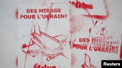 Grafiti yang pernyataan Presiden Prancis Emmanuel Macron yang berjanji untuk memasok Ukraina dengan jet tempur Mirage 2000-5 dilukis di dinding, di Paris, Prancis, 24 Juni 2024. Grafiti tersebut bertuliskan “Jet tempur Mirage untuk Ukraina.” (Foto: Benoit Tessier/Reuters)