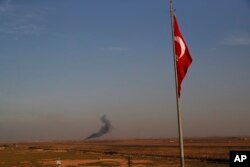 In this photo taken from the Turkish side of the border between Turkey and Syria, in Akcakale, Sanliurfa province, southeastern Turkey, smoke billows from a fire inside Syria during bombardment by Turkish forces Wednesday, Oct. 9, 2019.
