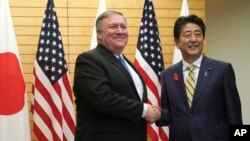 Menteri Luar Negeri AS Mike Pompeo (kiri), bersalaman dengan Perdana Menter Jepang Shinzo Abe di kantor Abe di Tokyo, 6 Oktober 2018.