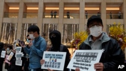 Protesters wearing masks hold placards reads" Close the border, say no to China" during a protest at a mall in Hong Kong, Tuesday, Feb. 4, 2020.
