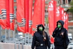 Petugas kepolisian mengenakan masker wajah berpatroli dalam hari peringatan kemenangan Rusia atas Nazi pada Perang Dunia II di tengah pandemi virus corona, di Moskow, Rusia, 9 Mei 2020. (Foto: Reuters)