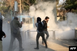 Iranian students run for cover from tear gas at the University of Tehran during a demonstration driven by anger over economic problems, in the capital Tehran, Dec. 30, 2017.