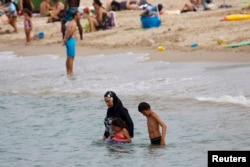 A Muslim woman wears a burkini, a swimsuit that leaves only the face, hands and feet exposed, on a beach in Marseille, France, August 17, 2016.
