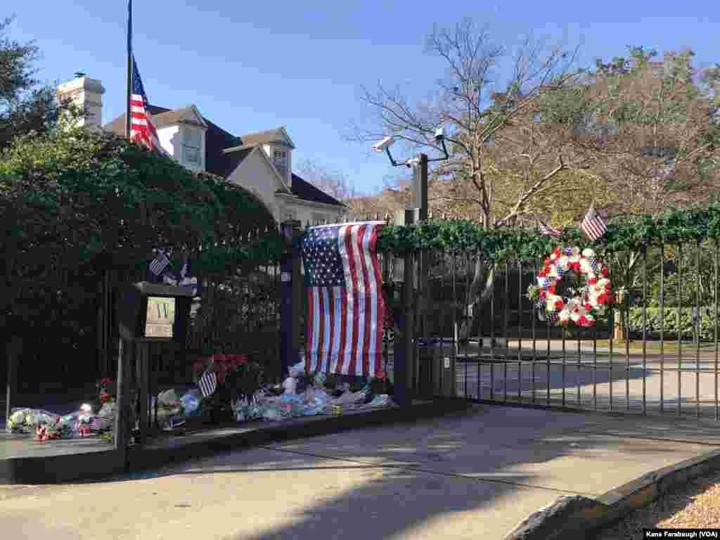 Flowers and flags from mourners create an impromptu memorial outside the gates of President George H.W. Bush&#39;s home in Houston, Texas, Dec. 5, 2018.