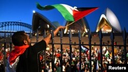 អ្នក​ចូល​រួម​ម្នាក់​នៅ​ក្នុង​បាតុកម្ម​គាំទ្រ​ប៉ាឡេស្ទីន​នៅ​ខាង​ក្រៅ​សាល Sydney Opera House នៅ​ទីក្រុង Sydney ប្រទេស​អូស្ត្រាលី កាល​ពី ថ្ងៃទី​៩ ខែ​តុលា ឆ្នាំ​២០២៣។