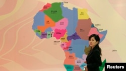一名中国女子走过在上海召开的非洲开发银行年度会议上张贴的非洲地图 （资料照片）